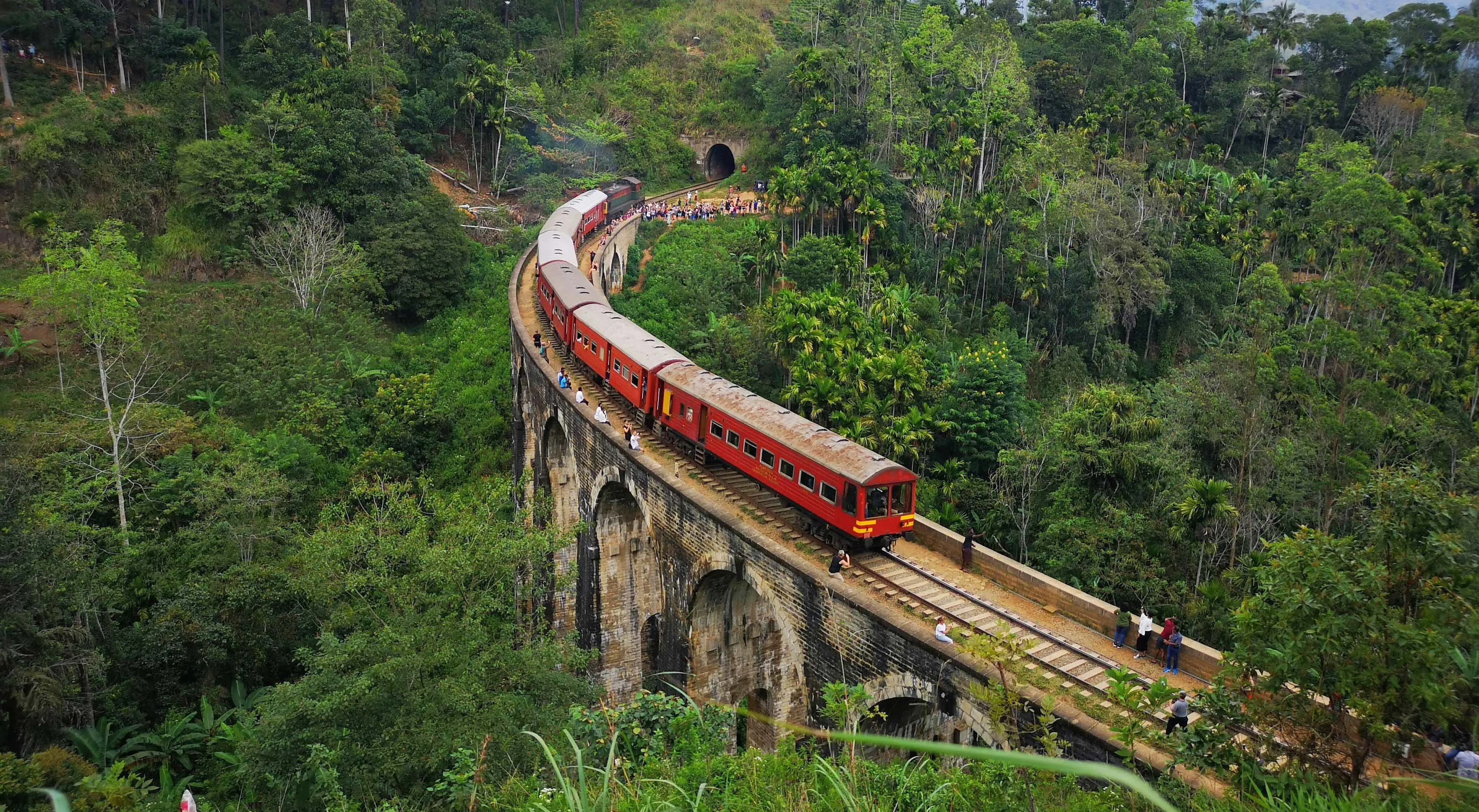 Scenic red train crossing Nine Arches Bridge in Ella, Sri Lanka